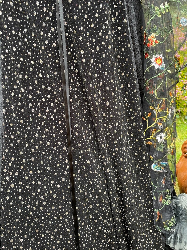 May include: Black sheer fabric with a silver glitter pattern and a black satin ribbon down the center.