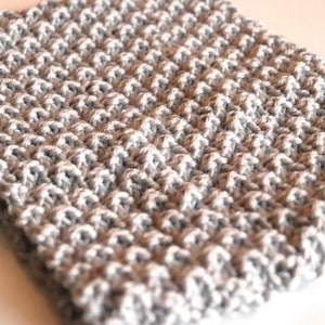 gray knitted seed stitch cowl scarf laying on a table