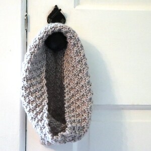 gray knitted seed stitch cowl scarf hanging from a doorknob