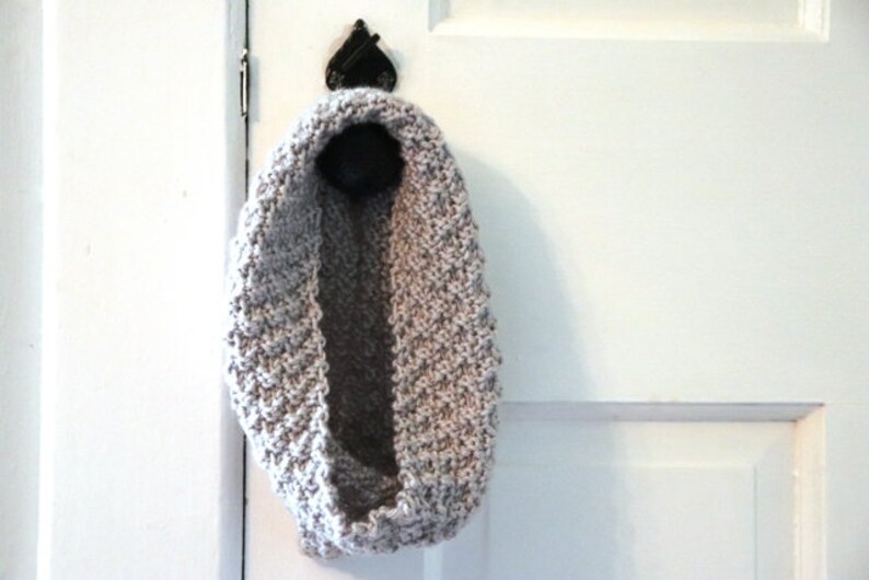 gray knitted seed stitch cowl scarf hanging from a doorknob