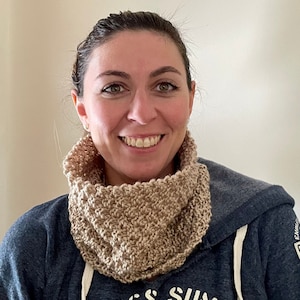 beige knitted seed stitch cowl scarf on a smiling woman