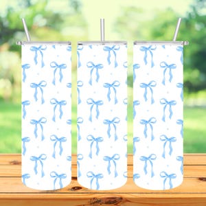 May include: Three stainless steel tumblers with a white background and a repeating pattern of blue bows.