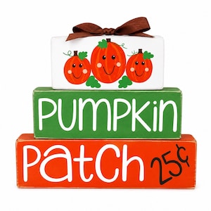 May include: A stack of three rectangular wooden blocks. The top white block features three orange pumpkins with green leaves and a brown ribbon bow. The middle green block says PUMPKIN in white. The bottom orange block says Patch 25¢ in white.