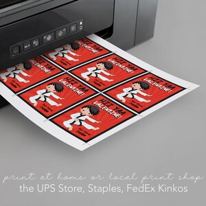 May include: A sheet of printable Valentine's Day cards featuring a cartoon karate kid with the text "Hi Yaa Valentine!" printed on a red background with black and white accents. The cards are being printed from a black printer.