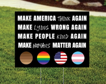 May include: Black rectangular yard sign with white text: "MAKE AMERICA THINK AGAIN, MAKE LYING WRONG AGAIN, MAKE PEOPLE KIND AGAIN, MAKE HUMANS MATTER AGAIN." Includes four circles with different designs.