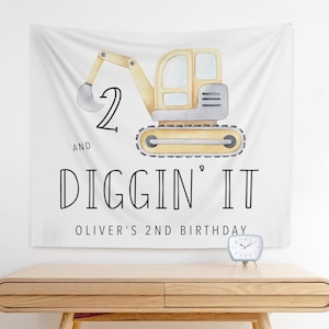 May include: White banner with a yellow and gray cartoon excavator with the text "2 and Diggin' It Oliver's 2nd Birthday"