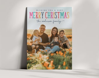 May include: A Christmas card featuring a family of four sitting in a field of orange flowers. The card reads "Wishing you a very Merry Christmas the Anderson family."