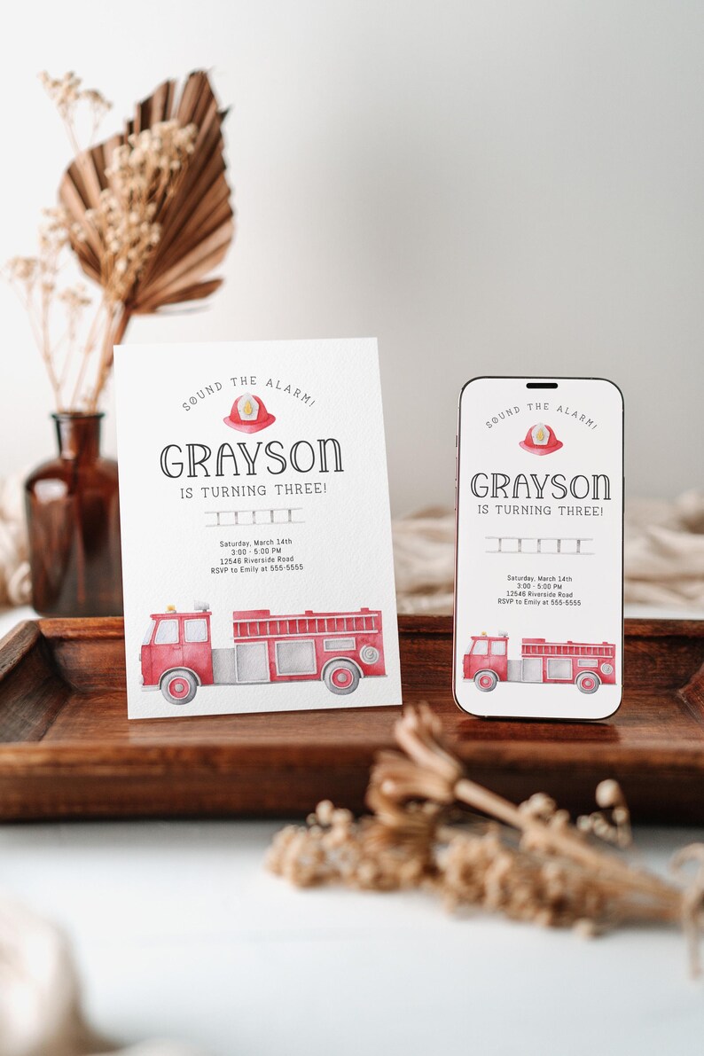 Puede incluir: Una tarjeta de invitaci&oacute;n rectangular blanca y una pantalla de tel&eacute;fono inteligente que muestra el mismo dise&ntilde;o: un cami&oacute;n de bomberos rojo en acuarela, un casco de bombero y el texto "SOUND THE ALARM! GRAYSON IS TURNING THREE!" con los detalles del evento.