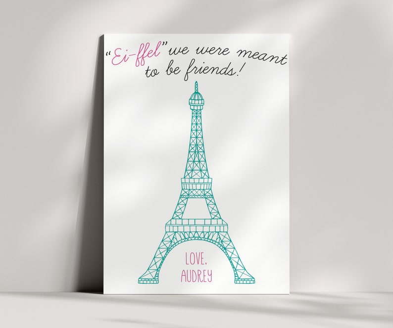 May include: A white canvas print with a teal Eiffel Tower illustration and the text "Ei-ffel" we were meant to be friends!" in pink cursive. The text "LOVE, AUDREY" is also in pink cursive at the bottom of the print.