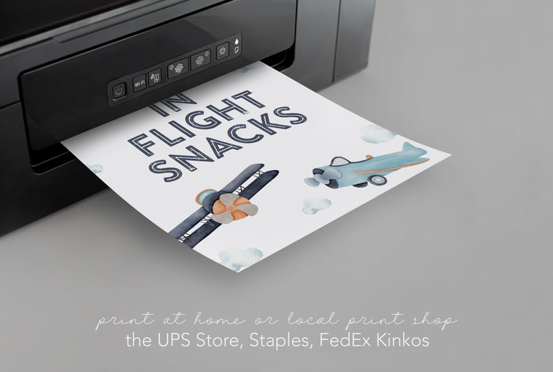 以下が含まれることがあります： 青と白の文字で「IN FLIGHT SNACKS」と書かれた印刷可能な看板。看板には、青と白の飛行機2機と雲を背景にした水彩画のイラストが描かれている。看板は白黒のプリンターで印刷されている。