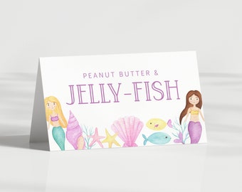 May include: A white card with a purple border and the text "Peanut Butter & Jelly-Fish" in purple. The card is decorated with two mermaids, seashells, starfish, and fish.