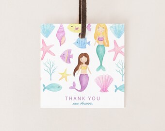 May include: A thank you tag with a watercolor illustration of mermaids, seashells, starfish, and fish. The text on the tag reads "Thank You xoxo, Arianna".