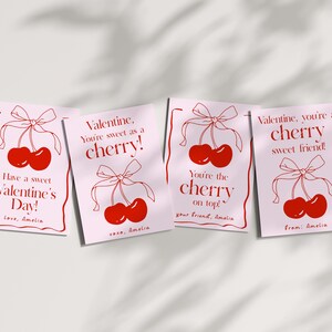 May include: Four pink Valentine's Day cards with red cherry illustrations and text that reads "Have a sweet Valentine's Day! Love, Amelia", "Valentine, you're sweet as a cherry! xoxo, Amelia", "You're the cherry on top! Your friend, Amelia", and "Valentine, you're a cherry sweet friend! From: Amelia".