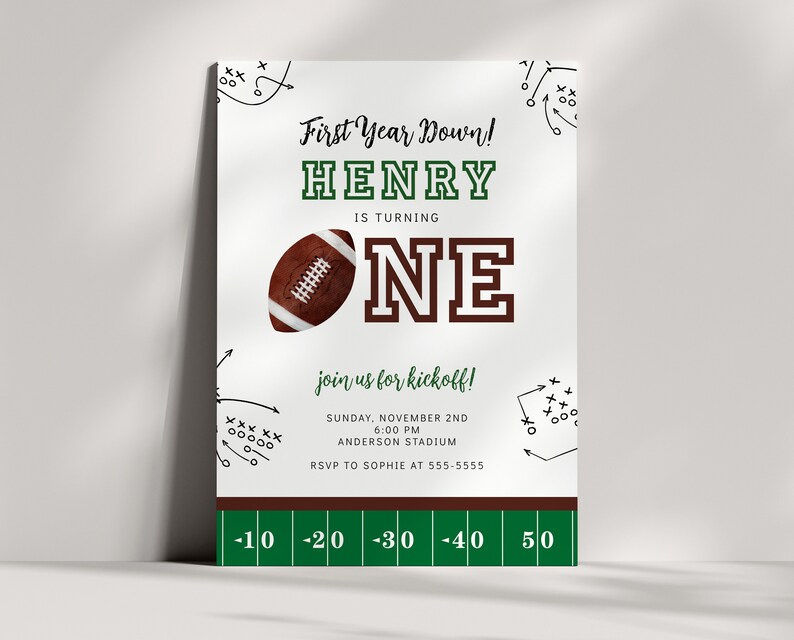 May include: A green and white football-themed first birthday party invitation for a boy named Henry. The invitation features a football, a green and white football field, and the text "First Year Down! Henry is turning One. Join us for kickoff! Sunday, November 2nd, 6:00 PM, Anderson Stadium. RSVP to Sophie at 555-5555."