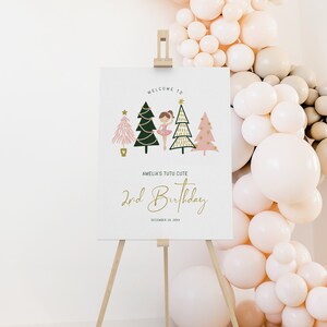 May include: Welcome to Amelia's Tutu Cute 2nd Birthday party sign with a ballerina and Christmas trees. The sign is on a wooden easel.