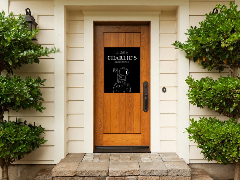 May include: A black and white welcome sign with the text "Welcome to Charlie's Space Station" and a cartoon astronaut standing on the moon.