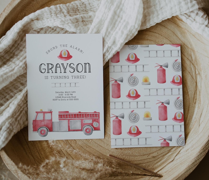 A birthday invitation with a red fire truck and a firefighter helmet. The text reads 'Sound the alarm! Grayson is turning three!  Backside features graphics of fire extinguisher, ladder, hat and hose.