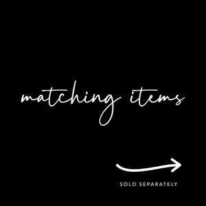 May include: A black graphic with white text that reads matching items in a cursive script. Below the text is a white curved arrow pointing to the right, with the text SOLD SEPARATELY printed in a clean, sans-serif font underneath the arrow.