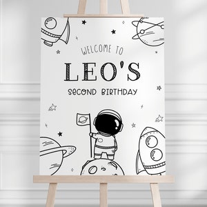 K&ouml;nnte beinhalten: Schwarzwei&szlig;es druckbares Schild mit einem Astronauten, Planeten, Sternen und Raketen. Das Schild lautet "Willkommen zu Leos zweitem Geburtstag".