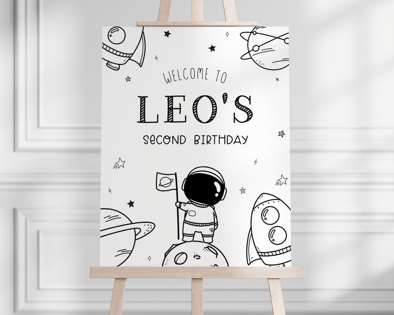 K&ouml;nnte beinhalten: Schwarzwei&szlig;es druckbares Schild mit einem Astronauten, Planeten, Sternen und Raketen. Das Schild lautet "Willkommen zu Leos zweitem Geburtstag".