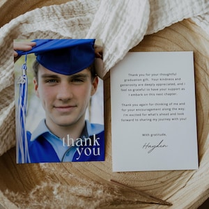 May include: A graduation thank you card featuring a young person in a blue graduation cap and gown. The card has the words "thank you" printed on the front. A second card with a message is also visible.