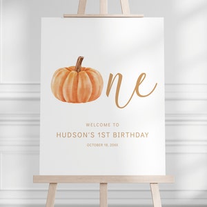 Könnte beinhalten: Ein weißes Schild mit einem Aquarellkürbis und dem Wort "one" in goldener Schrift. Das Schild lautet "Willkommen zum 1. Geburtstag von Hudson, 18. Oktober 20XX".