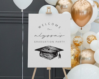 Può includere: Un cartello di benvenuto per una festa di laurea su un cavalletto di legno. Il cartello recita "Benvenuti alla festa di laurea di Alyssa" con un disegno di un cappello di laurea. Palloncini bianchi, dorati e con coriandoli decorano lo sfondo.