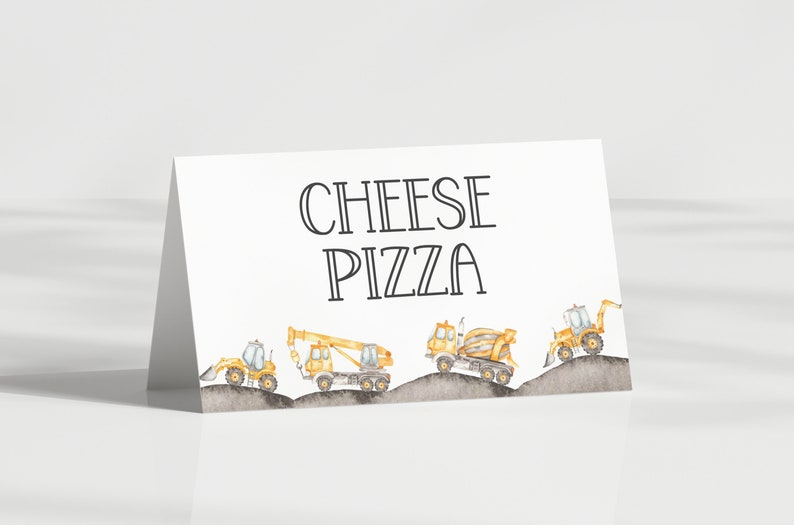 May include: A white card with the text "CHEESE PIZZA" in black outlined letters.  The card has a border of five yellow construction vehicles driving on a grey dirt road.