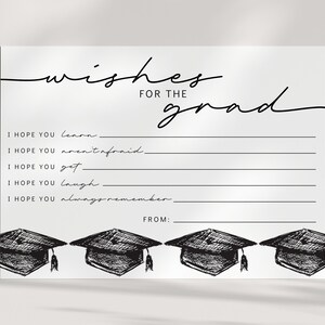 Pu&ograve; includere: Un biglietto di laurea bianco con la scritta nera "wishes for the grad". Il biglietto presenta righe da compilare e illustrazioni di cappelli di laurea. Il testo include "I hope you learn", "I hope you aren't afraid" e "From:"