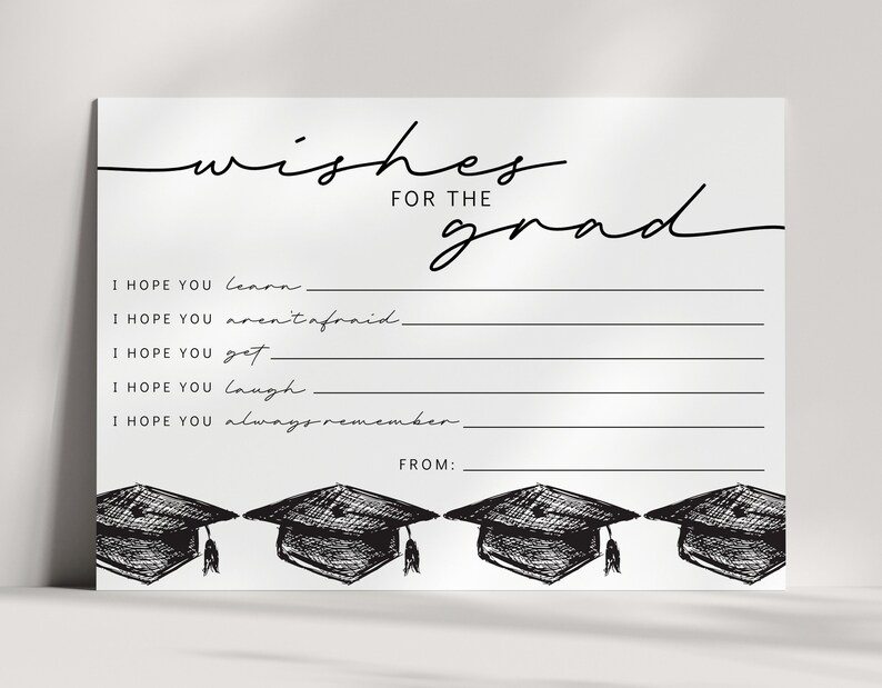 Pu&ograve; includere: Un biglietto di laurea bianco con la scritta nera "wishes for the grad". Il biglietto presenta righe da compilare e illustrazioni di cappelli di laurea. Il testo include "I hope you learn", "I hope you aren't afraid" e "From:"