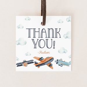 May include: Thank you tag with a blue and orange airplane design. The tag has a white background with blue clouds and the text "Thank You! - Hudson".