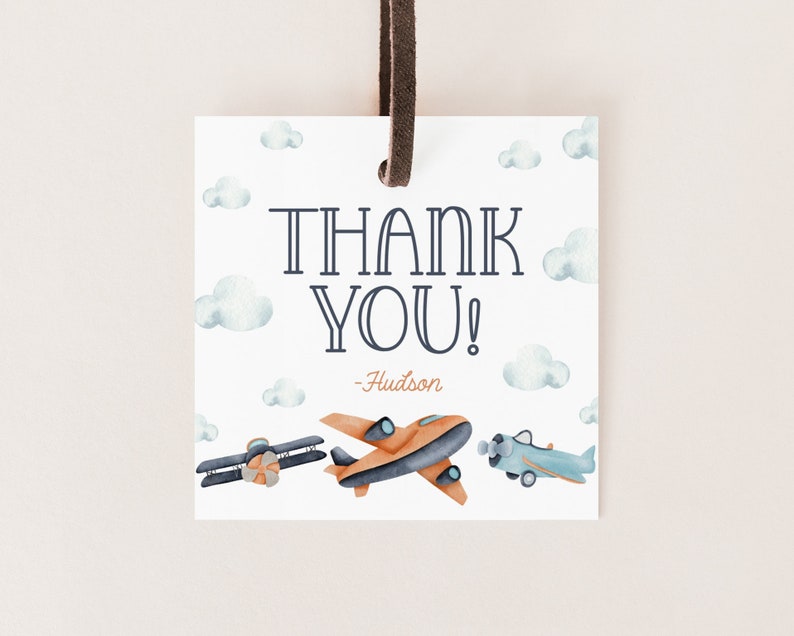 May include: Thank you tag with a blue and orange airplane design. The tag has a white background with blue clouds and the text "Thank You! - Hudson".