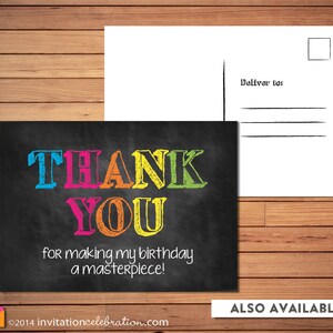 May include: A black chalkboard thank you card with colourful text that reads "THANK YOU for making my birthday a masterpiece!" The card is a postcard with a blank space for a message and an address on the back.