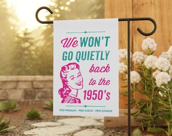 May include: A white garden flag with a pink and teal graphic of a woman with the text "We won't go quietly back to the 1950's" and the text "Pro Woman - Pro Child - Pro Choice".