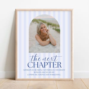 May include: A framed vertical print featuring a light blue and white striped background with a central arched photo of a person at the beach. Below the photo, the text reads: the next CHAPTER, ADDISON IS HEADING TO INDIANA UNIVERSITY WITH PLANS TO STUDY COMMUNICATIONS AND MARKETING.