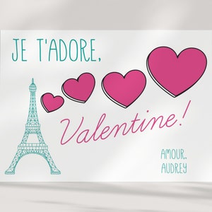 May include: A white card with a teal Eiffel Tower, pink hearts, and the text "Je t'adore, Valentine! Amour, Audrey".