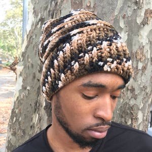 May include: A brown, black, and white camouflage beanie hat.