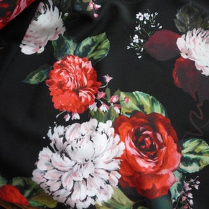May include: Black fabric with a floral print featuring red, white, and burgundy roses, peonies, and small white flowers.