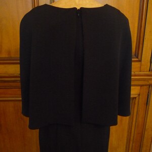 May include: A black dress with a long skirt and a short, fitted top. The dress has a zipper in the back.