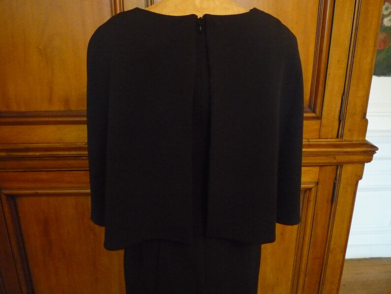 May include: A black dress with a long skirt and a short, fitted top. The dress has a zipper in the back.
