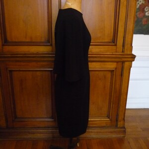 May include: A black knee-length dress with a round neckline and three-quarter sleeves.