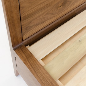 Peut inclure: Gros plan d'une structure de lit en bois avec une base &agrave; lattes. Le cadre est en bois de noyer fonc&eacute; et les lattes sont en bois clair.