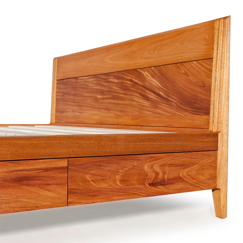 Peut inclure: Un cadre de lit en bois avec une t&ecirc;te de lit et deux tiroirs. Le cadre est en bois brun rouge&acirc;tre riche avec un grain de bois naturel.