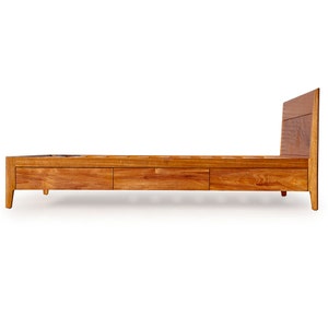 Peut inclure: Un cadre de lit en bois avec trois tiroirs et une t&ecirc;te de lit. Le cadre est en bois brun clair et a un design simple et moderne.