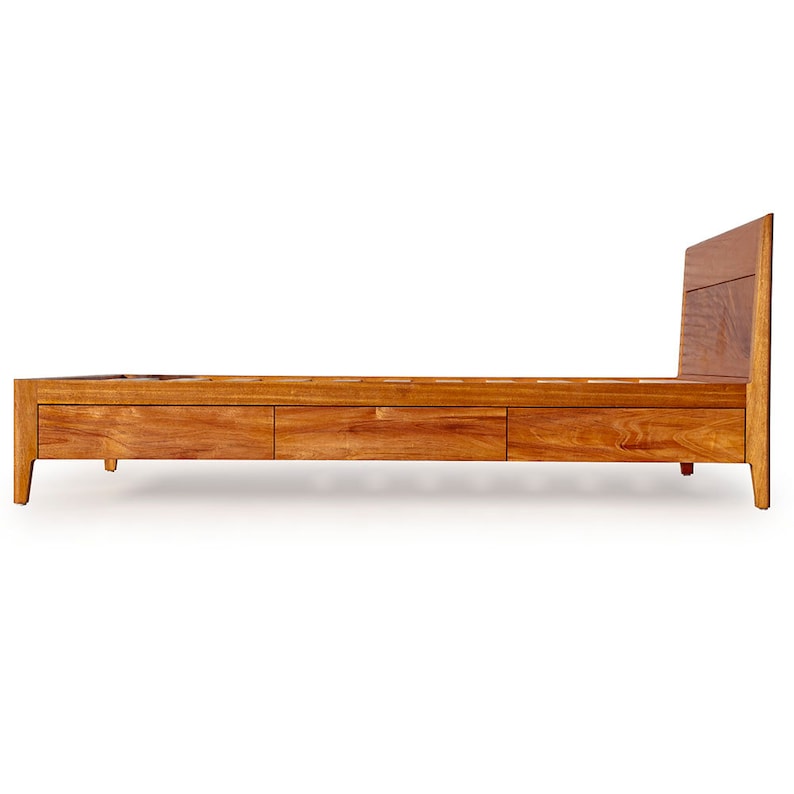 Peut inclure: Un cadre de lit en bois avec trois tiroirs et une t&ecirc;te de lit. Le cadre est en bois brun clair et a un design simple et moderne.