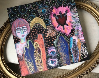 Puede incluir: Una pintura abstracta colorida sobre un lienzo negro con la cara de una mujer, un corazón con tres dagas y varios ojos. La pintura está enmarcada en un marco dorado.