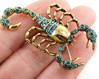 IN VACANZA Spilla a forma di scorpione, con piccoli strass blu, spilla vintage in ottone
