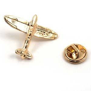 Puede incluir: Pin de metal dorado en forma de avi&oacute;n vintage con cierre de seguridad.