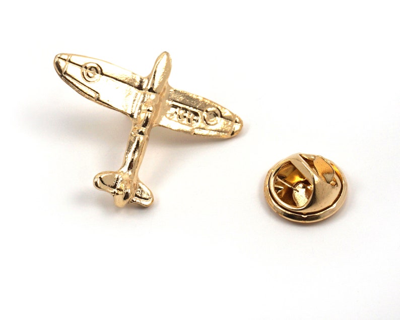 Puede incluir: Pin de metal dorado en forma de avi&oacute;n vintage con cierre de seguridad.