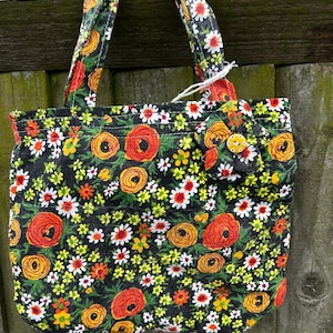 handmade handbag made from vintage fabric lining green fabric and a handmade flower on both sides